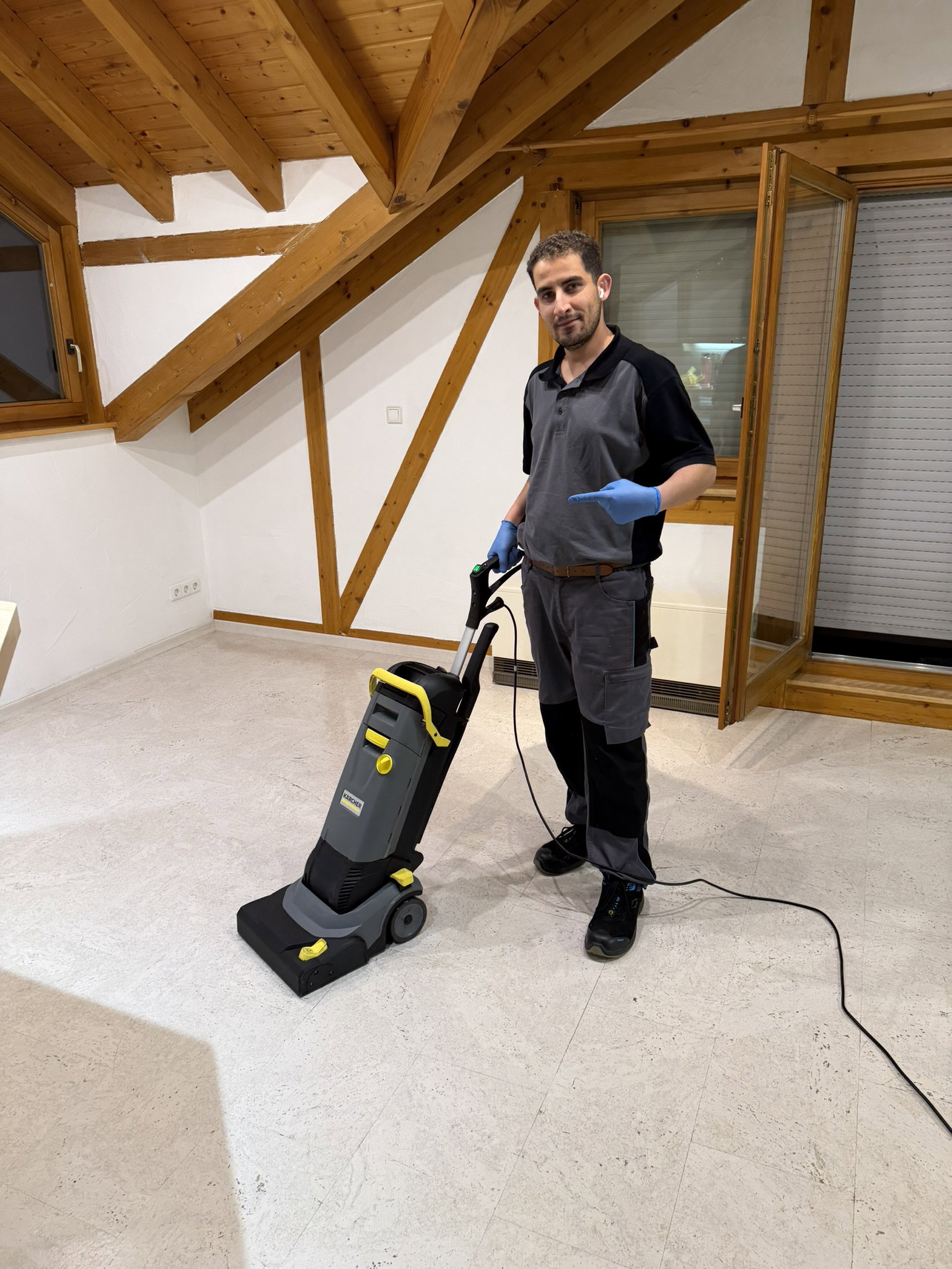 Mitarbeiter mit einer Scheuersaugmaschine in einer hellen Wohnung